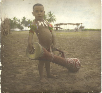 229028 Kleine jongen van de Marind-anim met een grote trommel op het strand